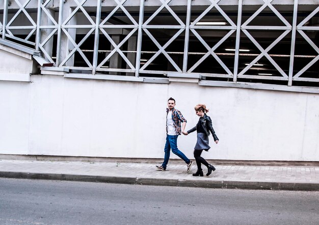 Pareja de enamorados caminando por la calle de una ciudad moderna