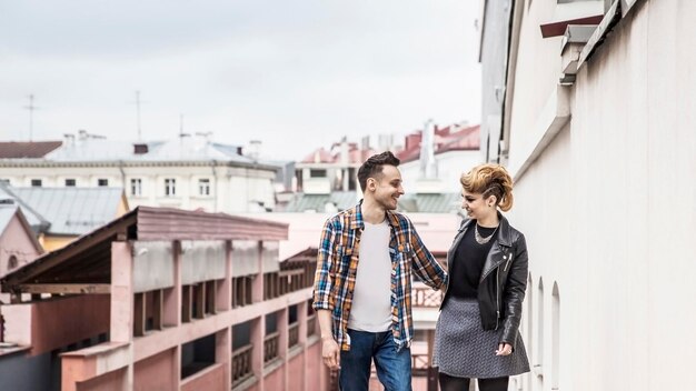 Pareja de enamorados caminando por la calle de una ciudad moderna