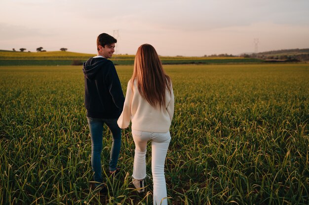 Pareja de enamorados caminando mientras se miran y se aman