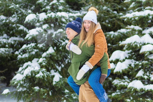 Foto pareja de enamorados celebra el día de san valentín, navidad, año nuevo. chico chica abrazando en vacaciones de invierno, en invierno en un día helado de nieve