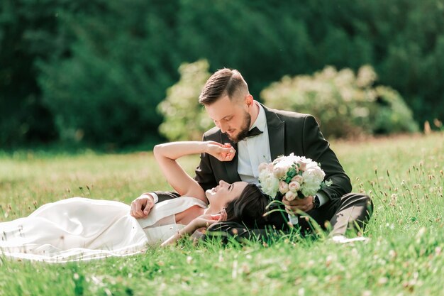 Foto pareja de enamorados en el césped en el parque de verano.