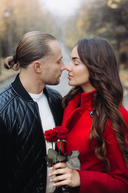 Una pareja de enamorados en una cita romántica en el parque de otoño