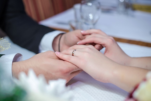 Pareja de enamorados cogidos de la mano en la mesa