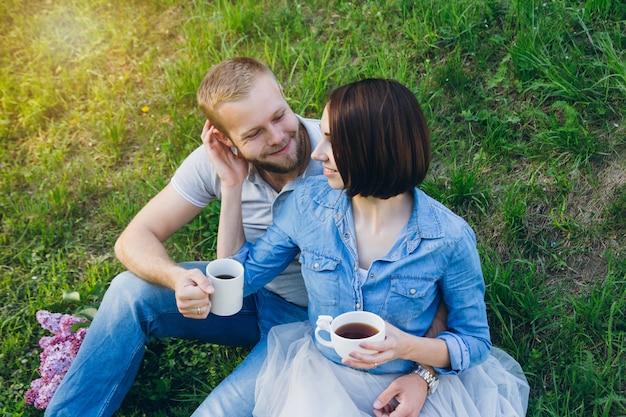 Pareja de enamorados descansa en el huerto de manzanas de verano