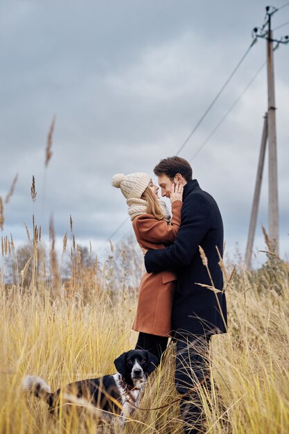 Pareja de enamorados en el día de San Valentín caminando en el parque con el perro.