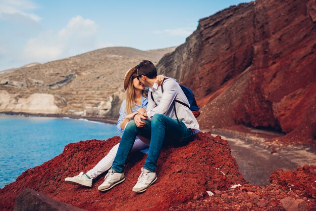 Pareja de enamorados disfrutando de luna de miel en playa roja