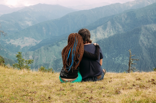 Pareja de enamorados disfrutando de la vista de majestuosas montañas