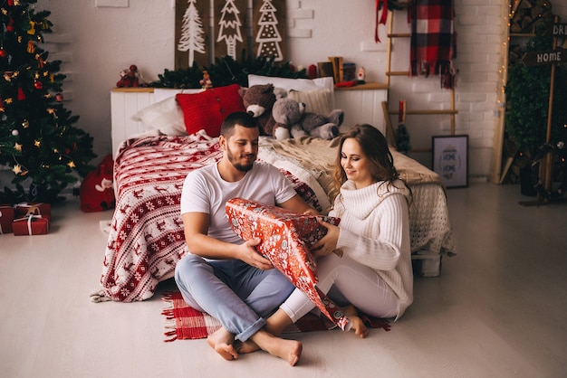 Pareja de enamorados empacando regalos de Navidad. Año nuevo