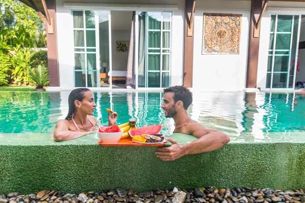 Pareja de enamorados en una hermosa villa con piscina.