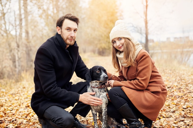 Pareja de enamorados paseando por el parque con el perro.