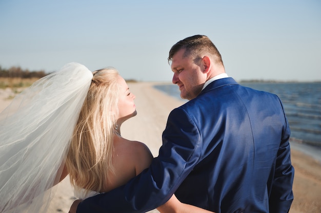 Pareja de enamorados en la playa el día de su boda.