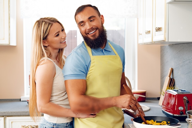 Foto pareja de enamorados preparando comida juntos en la cocina