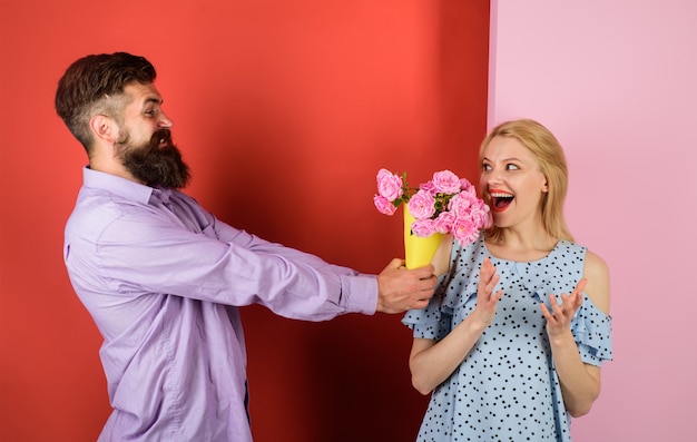 Pareja de enamorados con ramo de flores guapo barbudo da ramo de flores al amor de la mujer