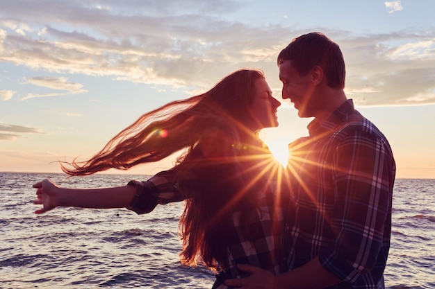 Pareja de enamorados retroiluminación silueta al atardecer lago