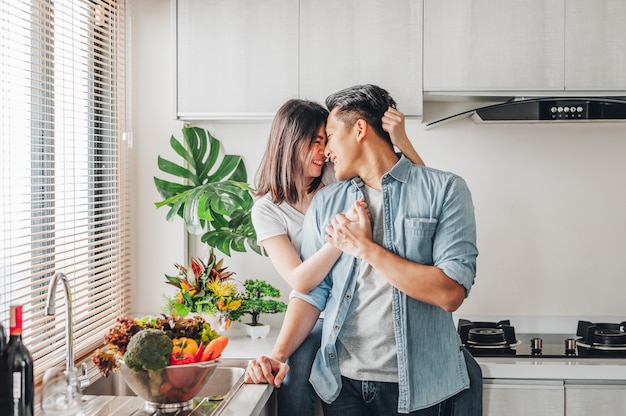 Pareja de enamorados riendo y pasando un buen rato juntos en la cocina