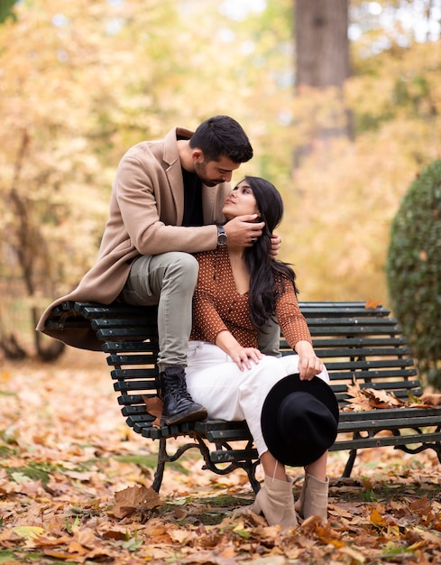 Pareja de enamorados sentados en un banco del parque