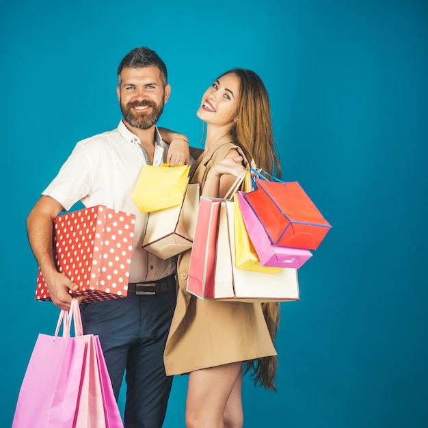 Pareja de enamorados tiene bolsa de compras cerca de la pared azul.