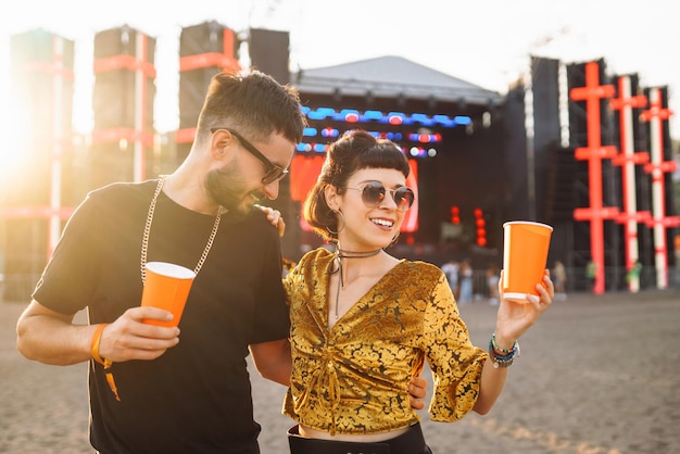 Una pareja encantadora divirtiéndose en el festival jóvenes amigos con cerveza en la fiesta de playa vacaciones de verano