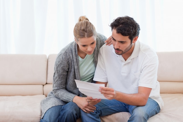 Pareja enfocada leyendo una carta