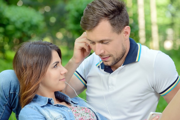 Pareja escuchando la música en picnic juntos