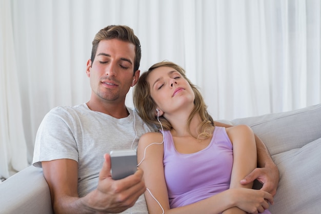 Pareja escuchando musica con telefono movil