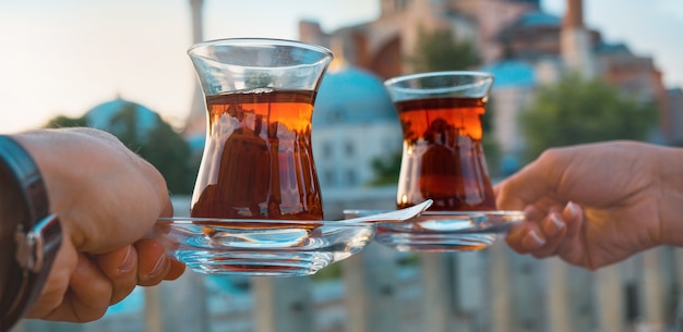 La pareja está bebiendo té turco en vasos de vidrio