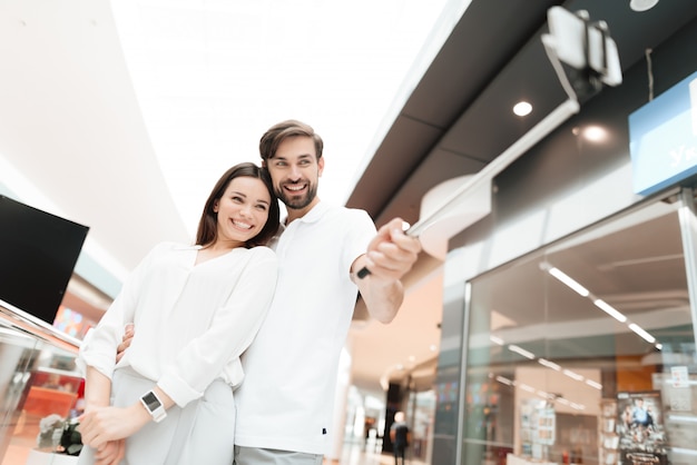 Pareja está tomando selfie con selfie stick.