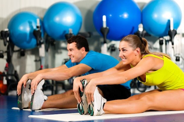 Pareja en estiramientos de gimnasio