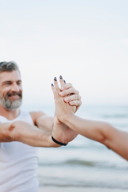 Pareja estirando en la playa