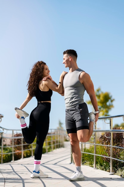 Pareja estirándose al aire libre antes de correr por la mañana