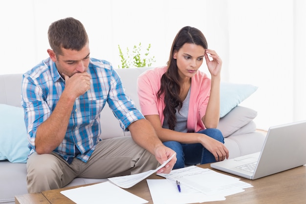 Foto pareja estresada calculando las finanzas del hogar