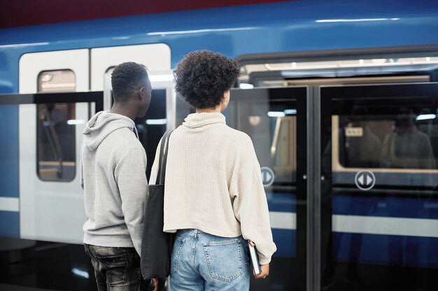 Pareja de estudiantes esperando un tren subterráneo