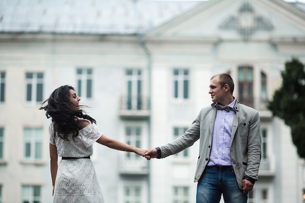 Pareja europea joven y hermosa pasando un buen rato en el fondo de la ciudad