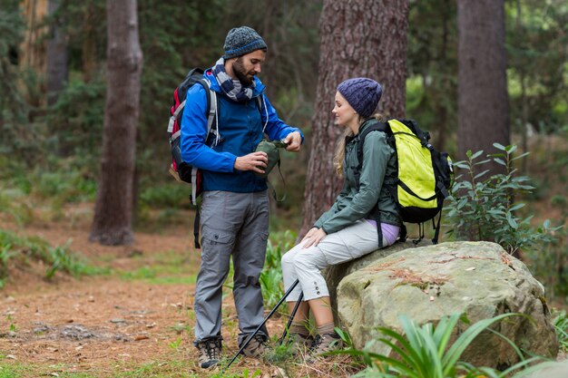 Pareja de excursionistas interactuando entre sí en el bosque