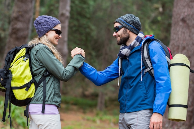 Pareja de excursionistas tomados de la mano en el bosque