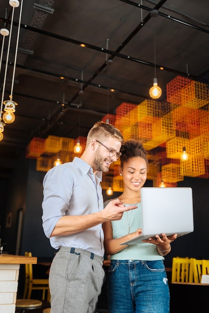 Pareja exitosa. Elegante pareja exitosa usando su computadora portátil mientras trabaja duro en su propio restaurante