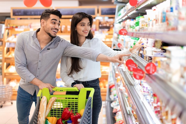 Pareja de familia árabe comprando comestibles comprando comida en el supermercado