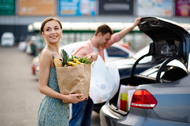 Pareja familiar pone sus compras en el maletero