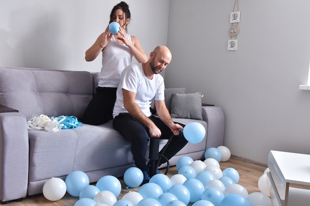 Pareja familiar, soplar, globos azules y blancos