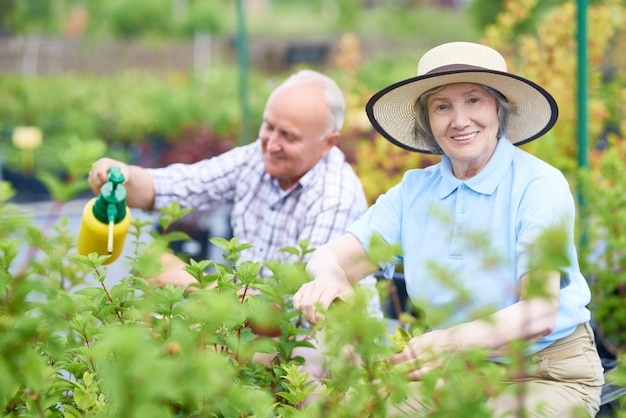 Pareja de felices agricultores mayores en jardín