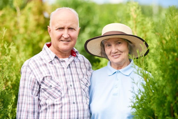 Pareja de felices agricultores mayores en jardín