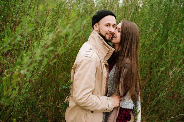 Una pareja feliz se abraza en el fondo verde de la naturaleza