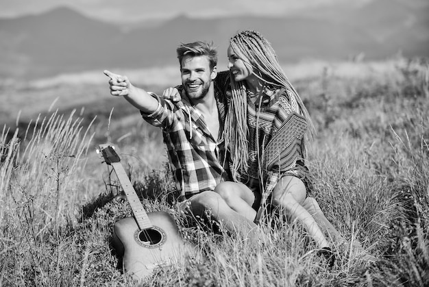 Pareja feliz abrazando el fondo de la naturaleza Caminata romántica Caminata familiar Novio y novia con guitarra en las montañas Disfrutando el uno del otro Caminata de verano Sentimientos impresionantes Senderismo romance