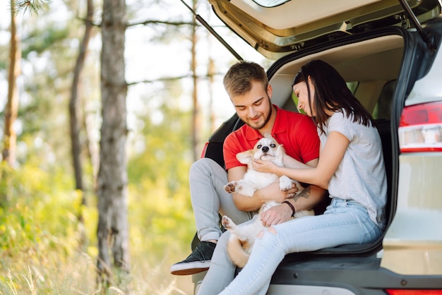 Foto una pareja feliz acaricia a su amado perro corgi concepto de estilo de vida vacaciones viajes familia