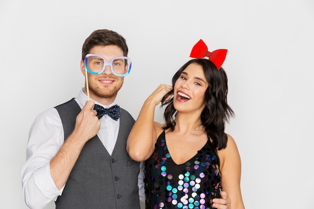 Foto pareja feliz con accesorios de fiesta divirtiéndose