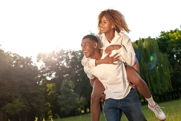 Una pareja feliz afroamericana camina juntos en el parque en verano y mira el espacio de copia.