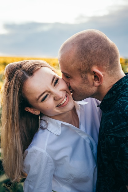 Una pareja feliz al atardecer se divierte y se besa.