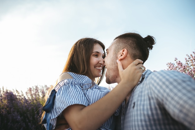 Una pareja feliz al atardecer se divierte y se besa.