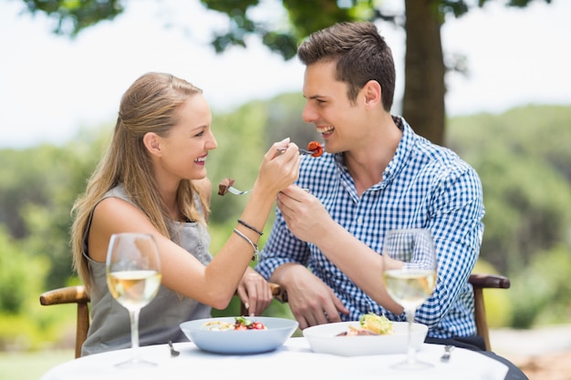 Pareja feliz alimentándose unos a otros