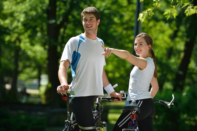 Pareja feliz andar en bicicleta al aire libre, concepto de romance de amor divertido de estilo de vida de salud
